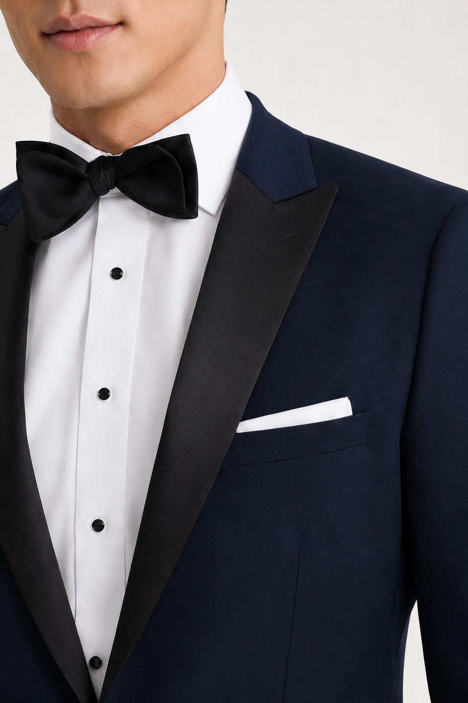 Navy tuxedo with black lapels and bow tie on a plain background